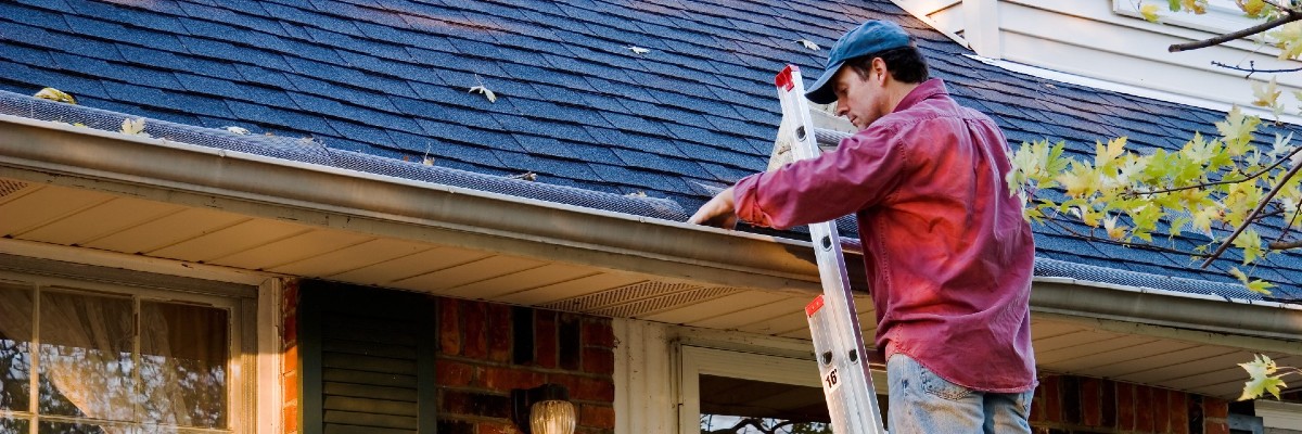 Climbing a ladder to clean gutters